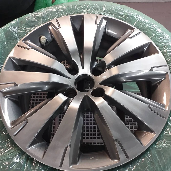 Véhicule blanc endommagé dans un garage automobile avec rayures et impacts visibles sur la carrosserie